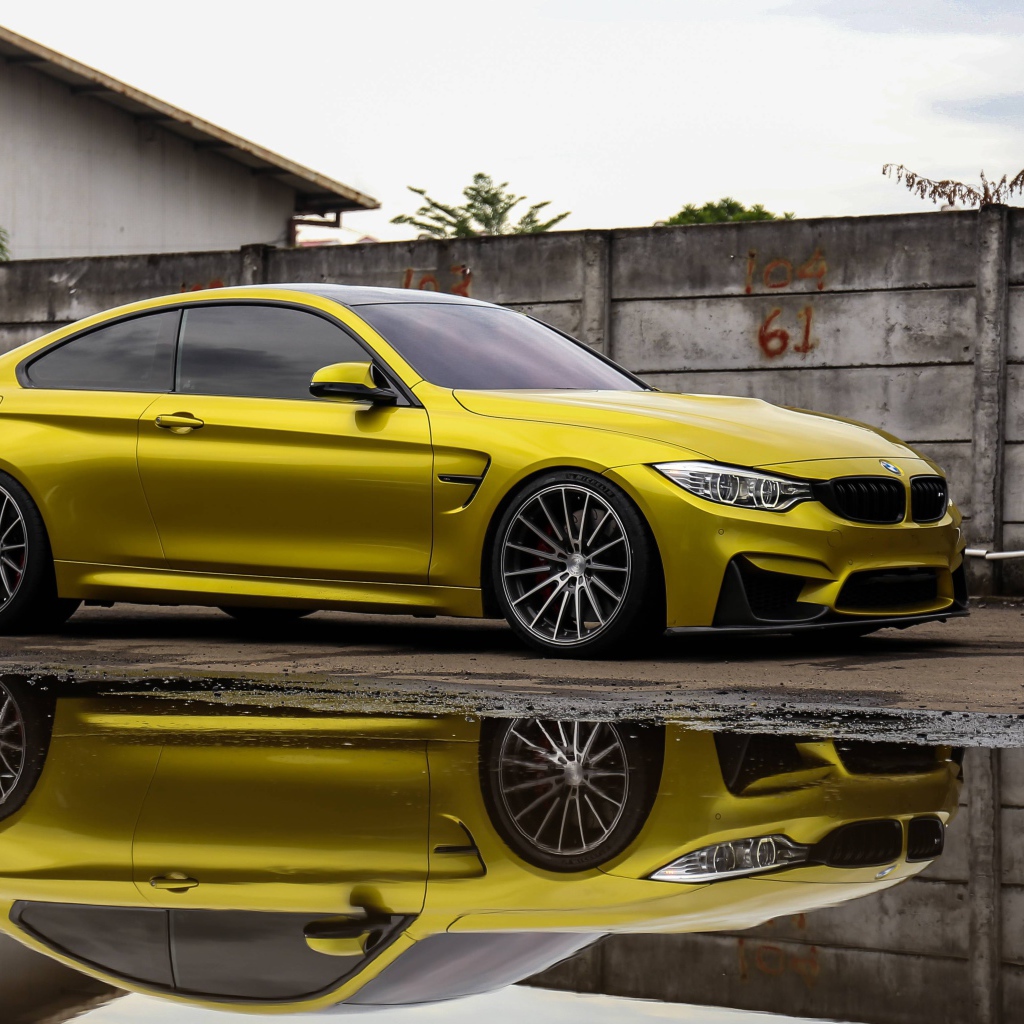 Желтый автомобиль BMW M5 отражается в воде 
