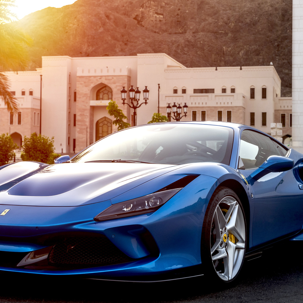 Голубой спортивный автомобиль Ferrari F8 Tributo 2019 года на фоне здания