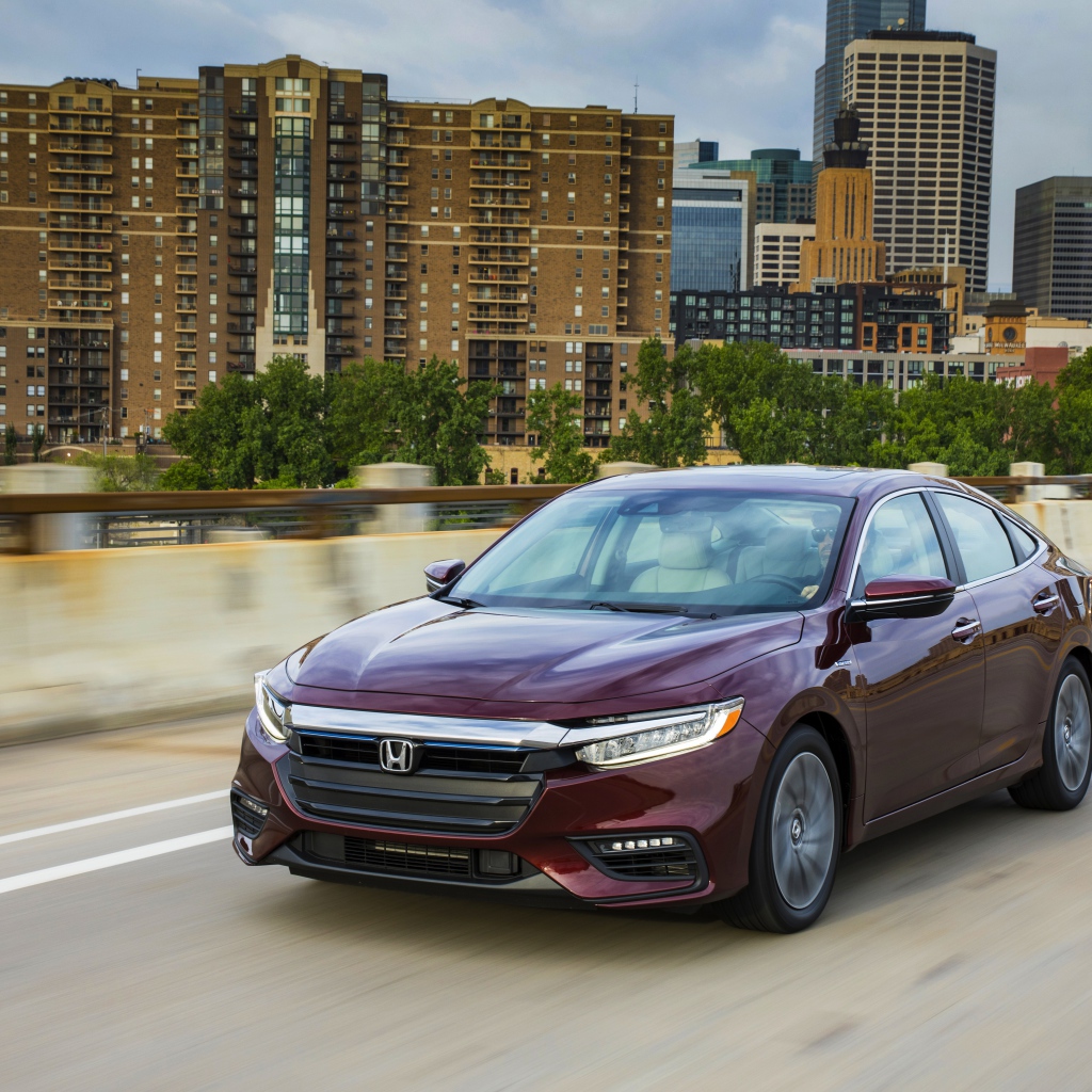 Бордовый автомобиль Honda Insight на фоне города