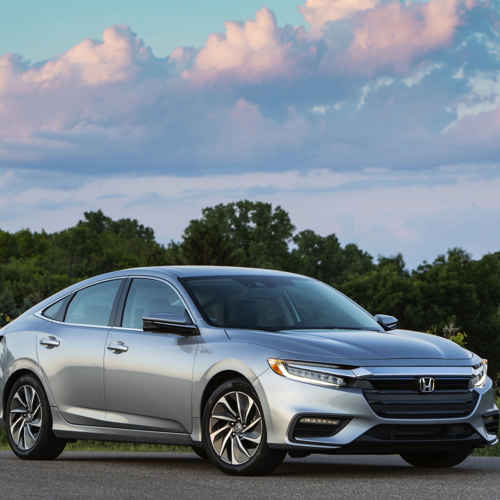 Серебристый автомобиль Honda Insight на фоне леса