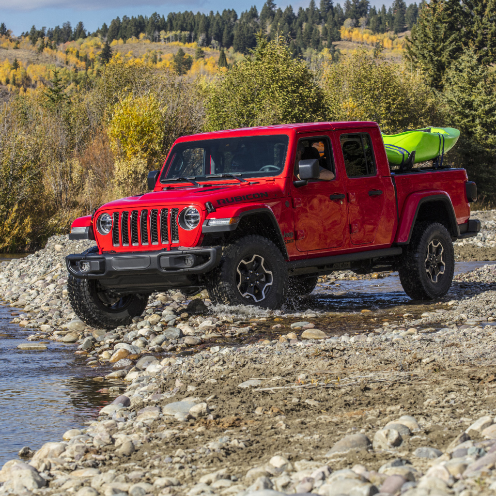 Красный пикап Jeep Gladiator Rubicon, 2020 года у реки