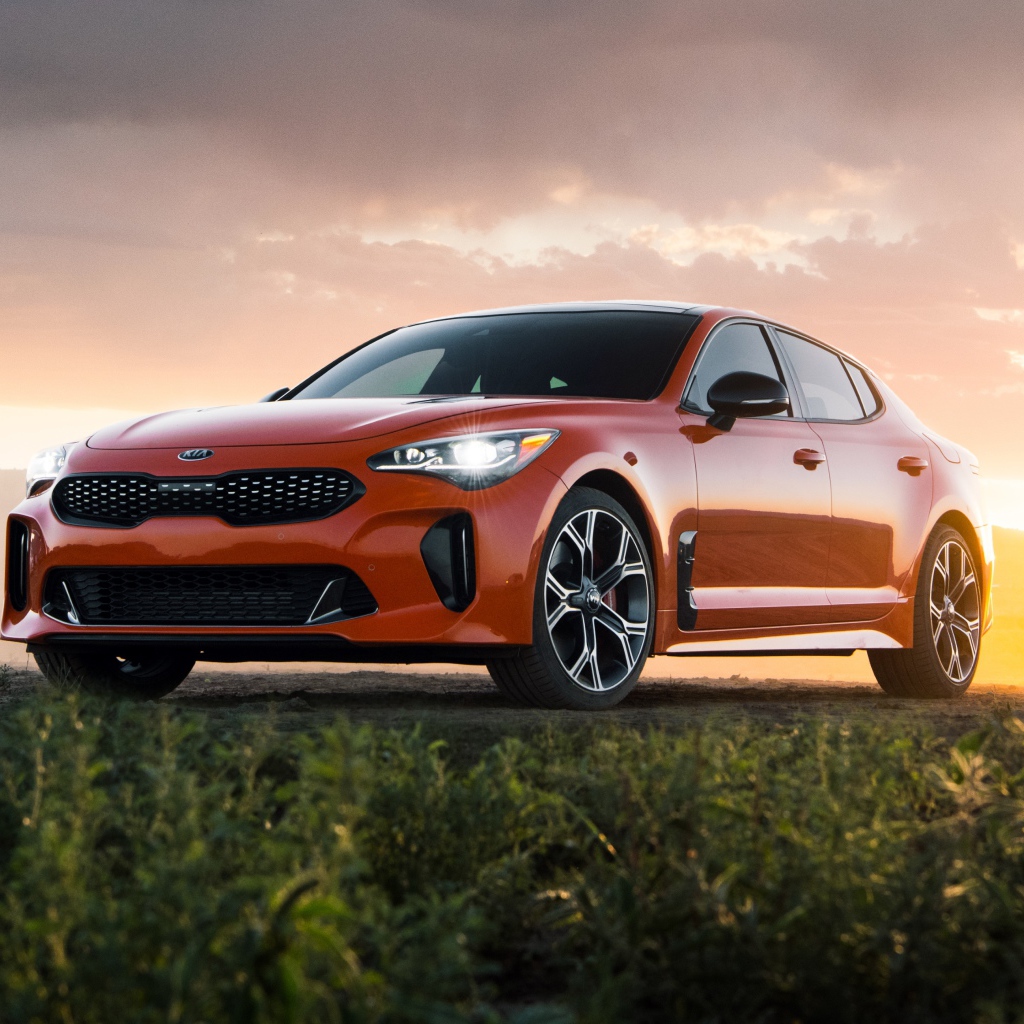 Оранжевый автомобиль  Kia Stinger GTS, 2020 года на закате