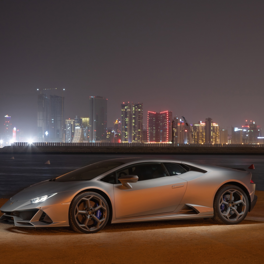 Серебристый автомобиль Lamborghini Huracan Evo на фоне города