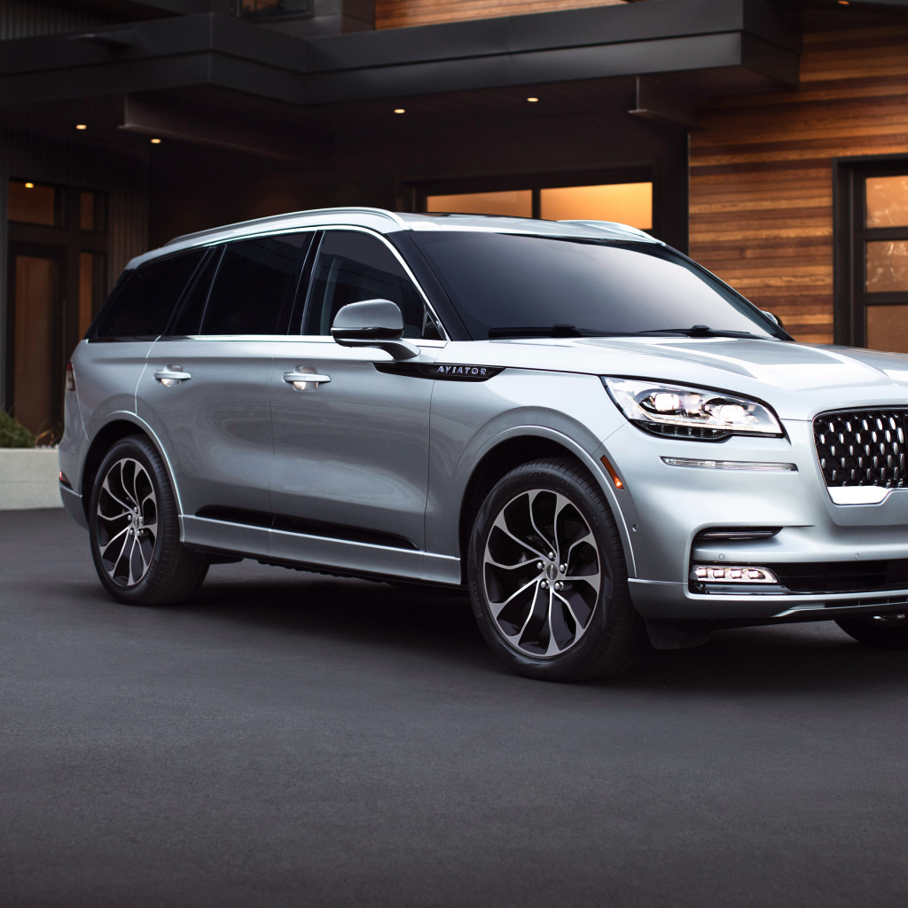 Серебристый внедорожник Lincoln Aviator Grand Touring, 2020 года на фоне дома