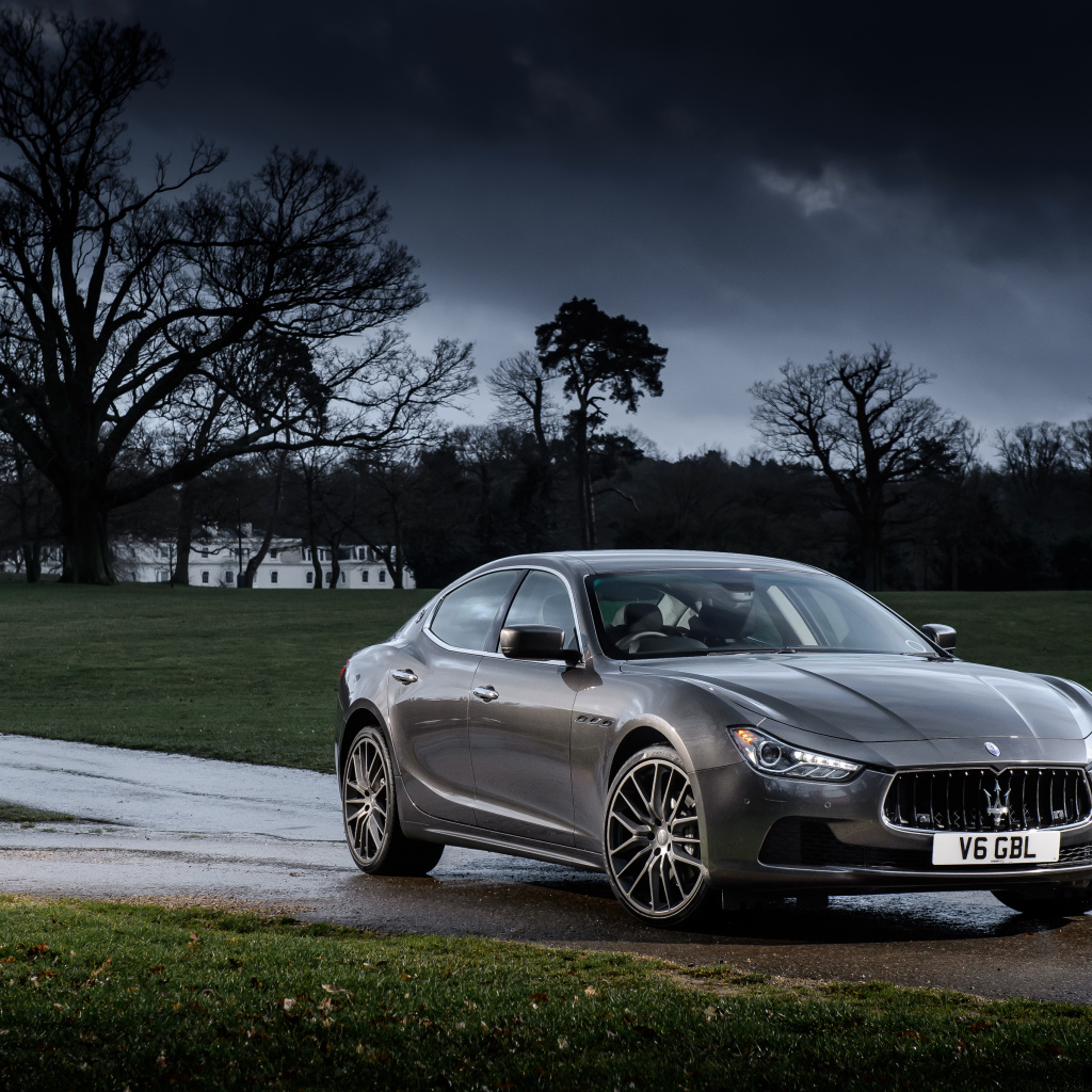 Серебристый автомобиль Maserati Ghibli на фоне грозового неба