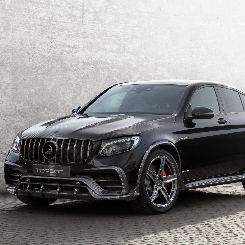 Черный стильный автомобиль Mercedes-AMG GLC-Klasse на фоне серой стены 