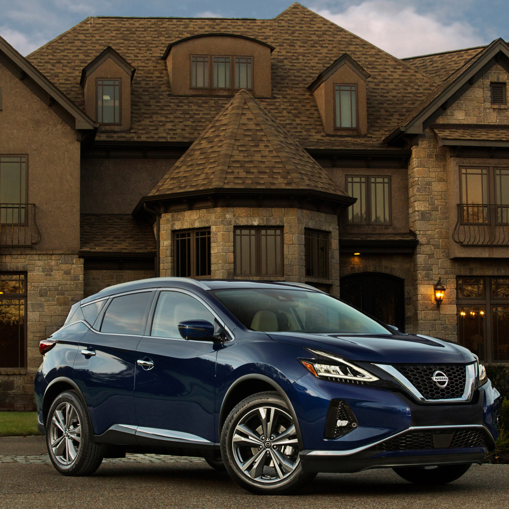 Синий автомобиль Nissan Murano на фоне особняка