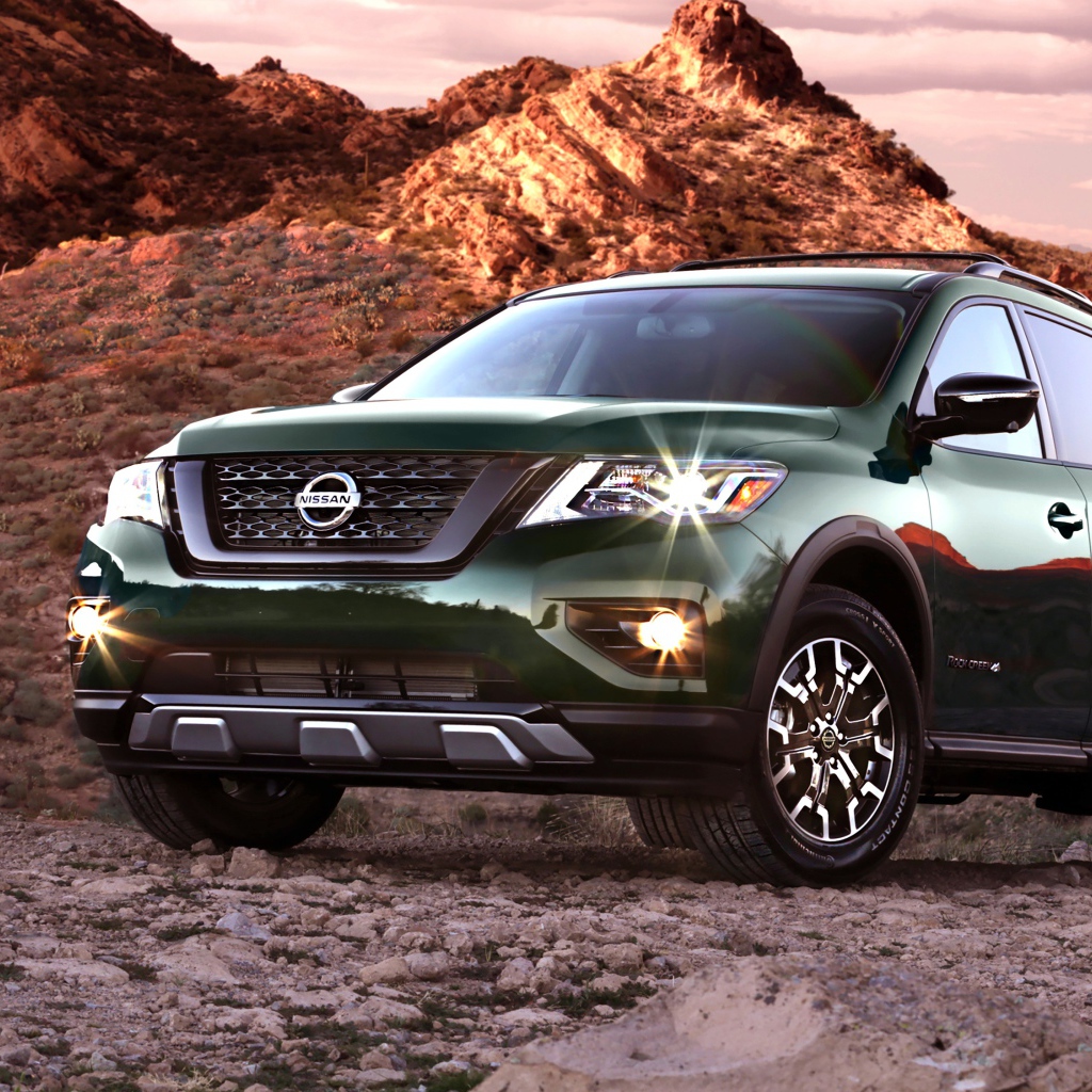 Зеленый автомобиль Nissan Pathfinder в горах 