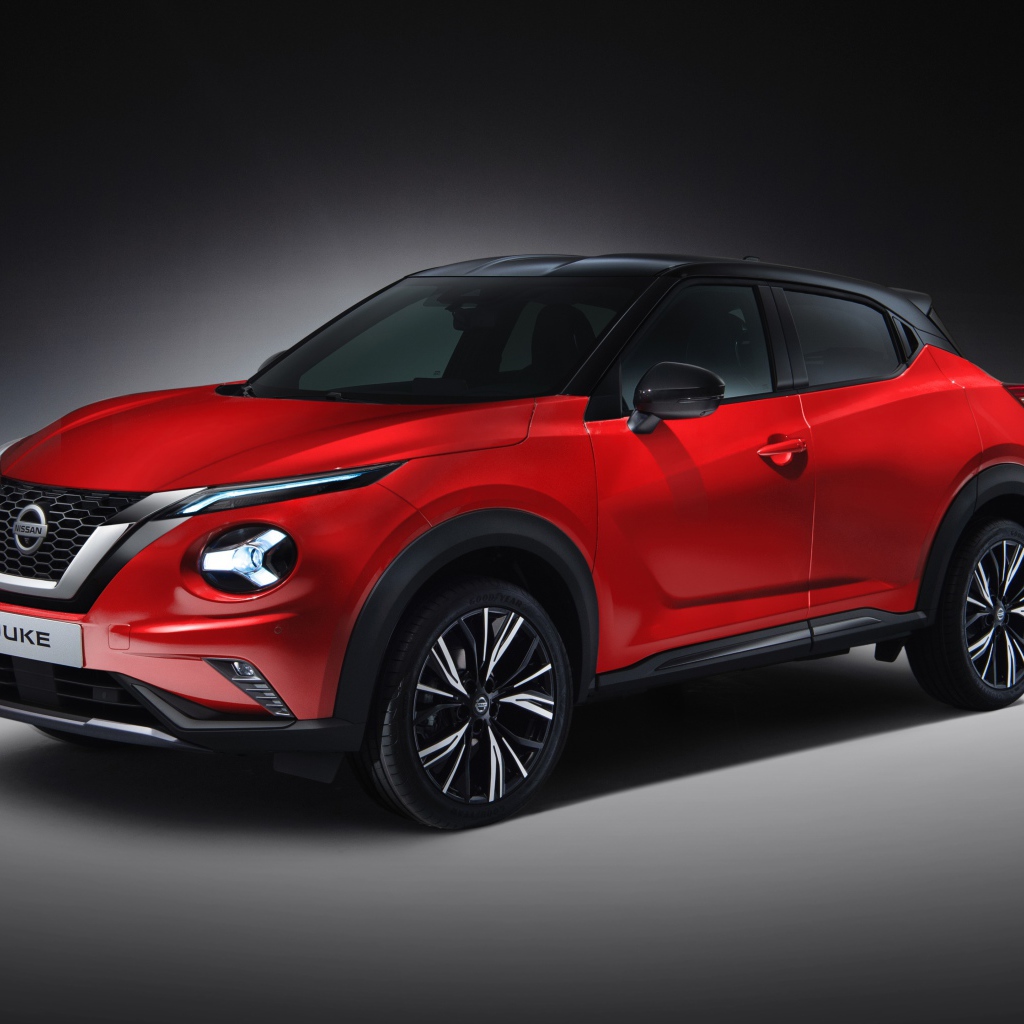 Красный автомобиль Nissan Juke 2019 года на сером фоне