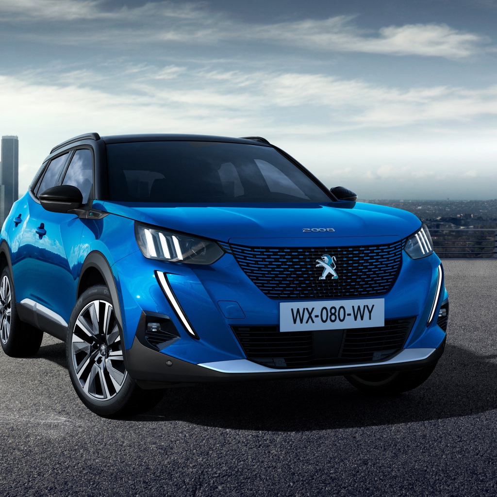 Синий внедорожник Peugeot E-2008 GT, 2019 года на фоне небоскребов