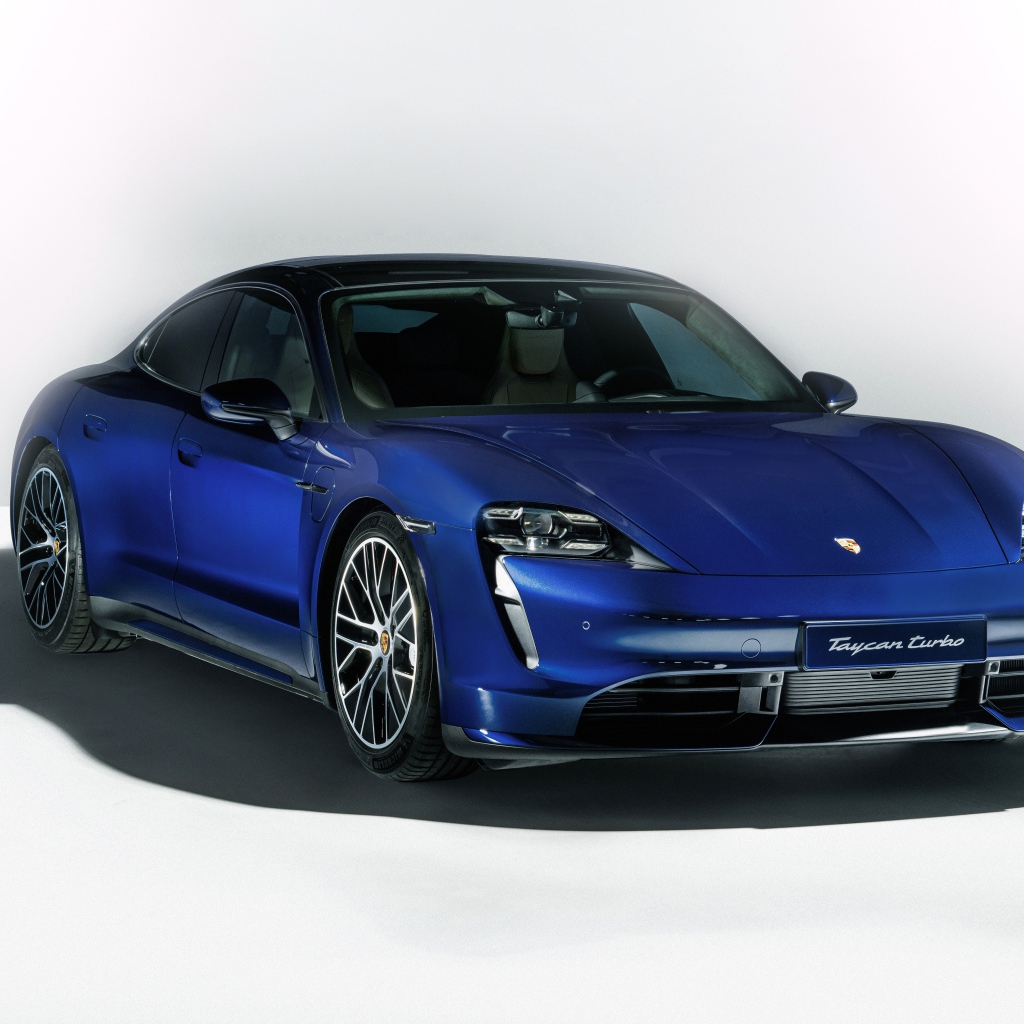 Синий автомобиль Porsche Taycan Turbo 2019 года на сером фоне