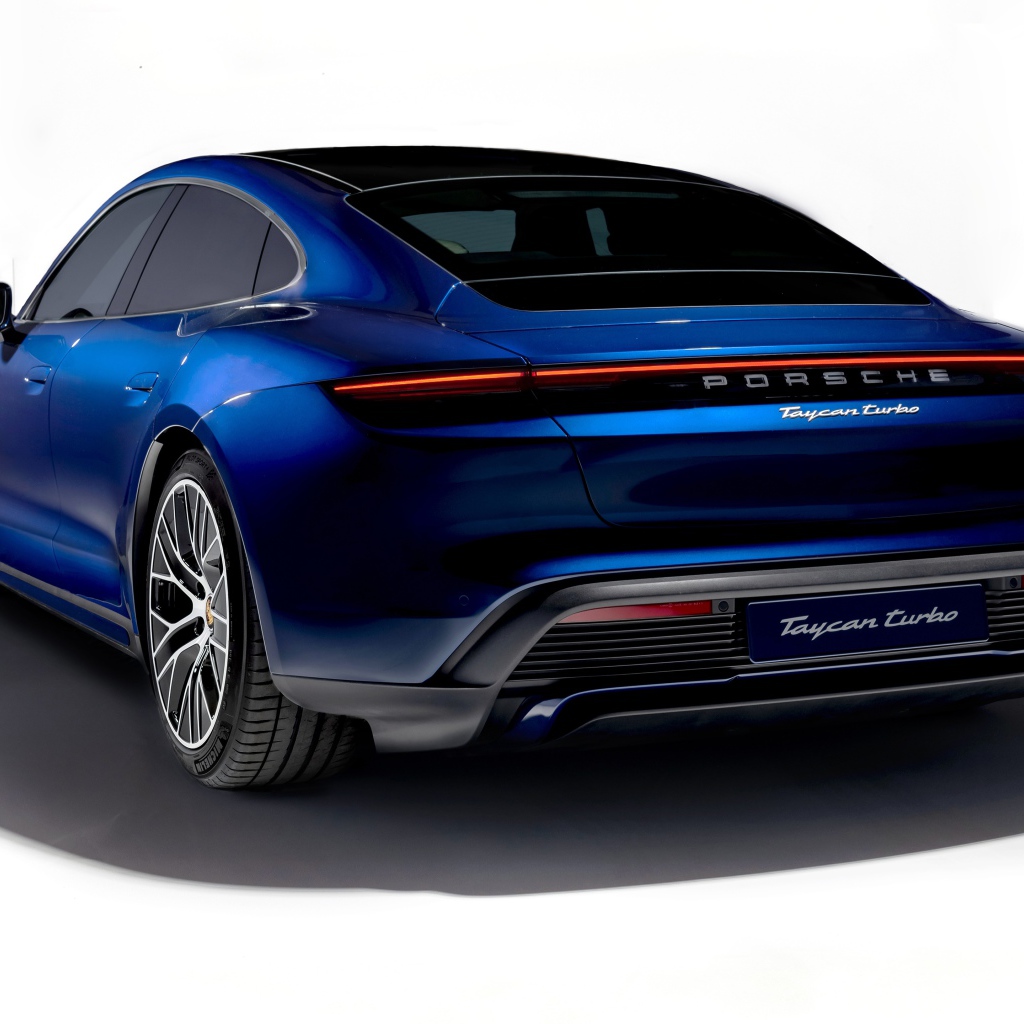 Синий автомобиль Porsche Taycan Turbo 2019 года на белом фоне