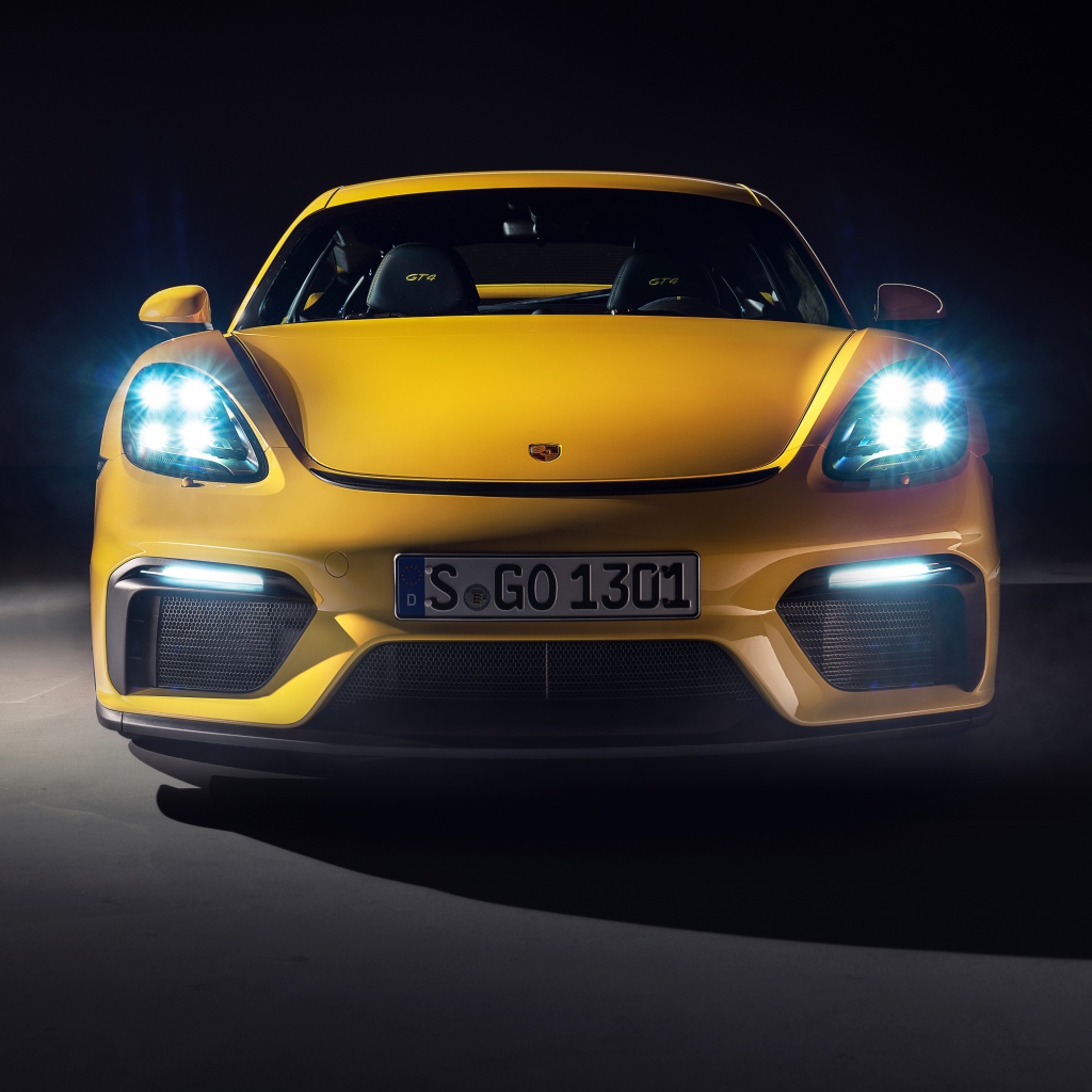Автомобиль Porsche 718 Cayman GT4,  2019 года с включенными фарами 