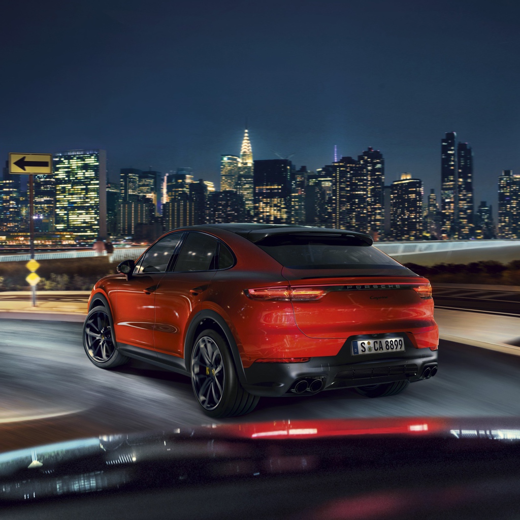 Красный внедорожник Porsche Cayenne Coupe 2019 года на фоне города