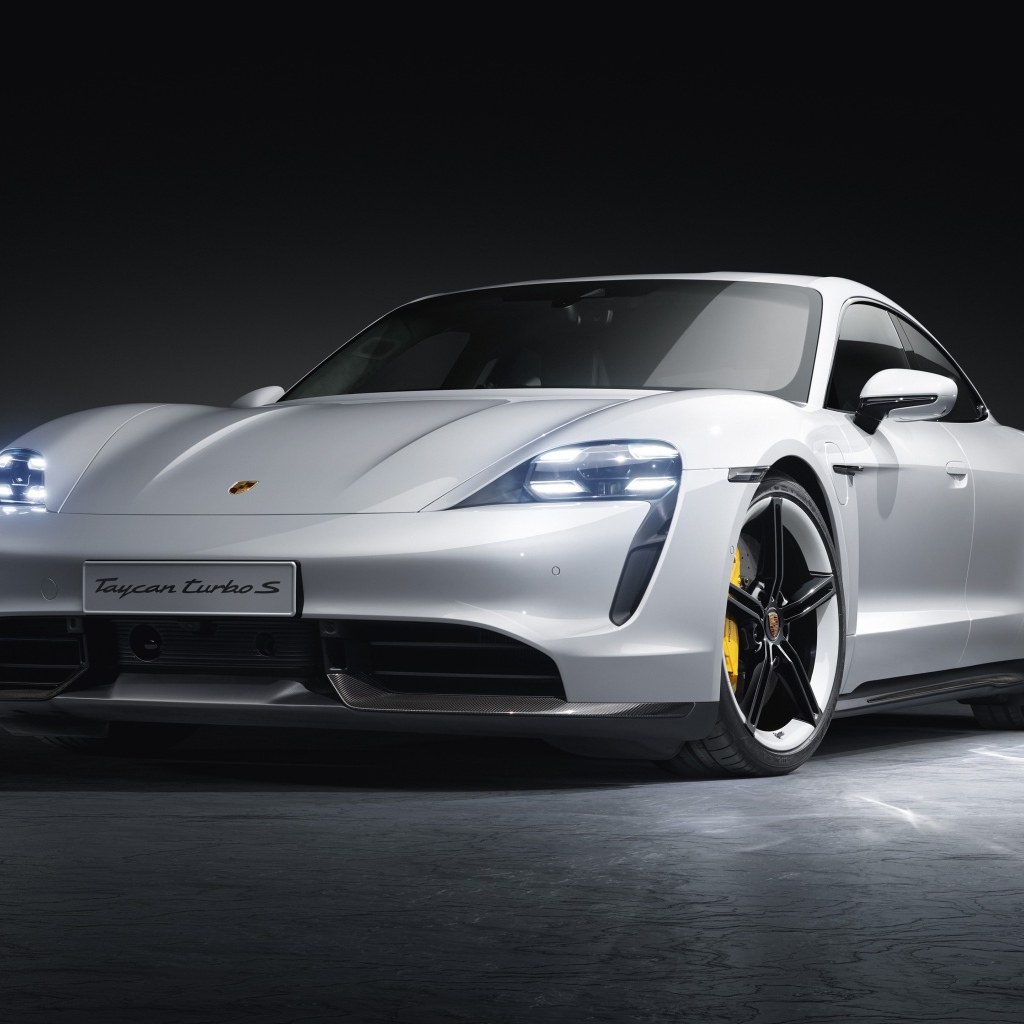 Серебристый автомобиль Porsche Taycan Turbo S 2019 года на сером фоне