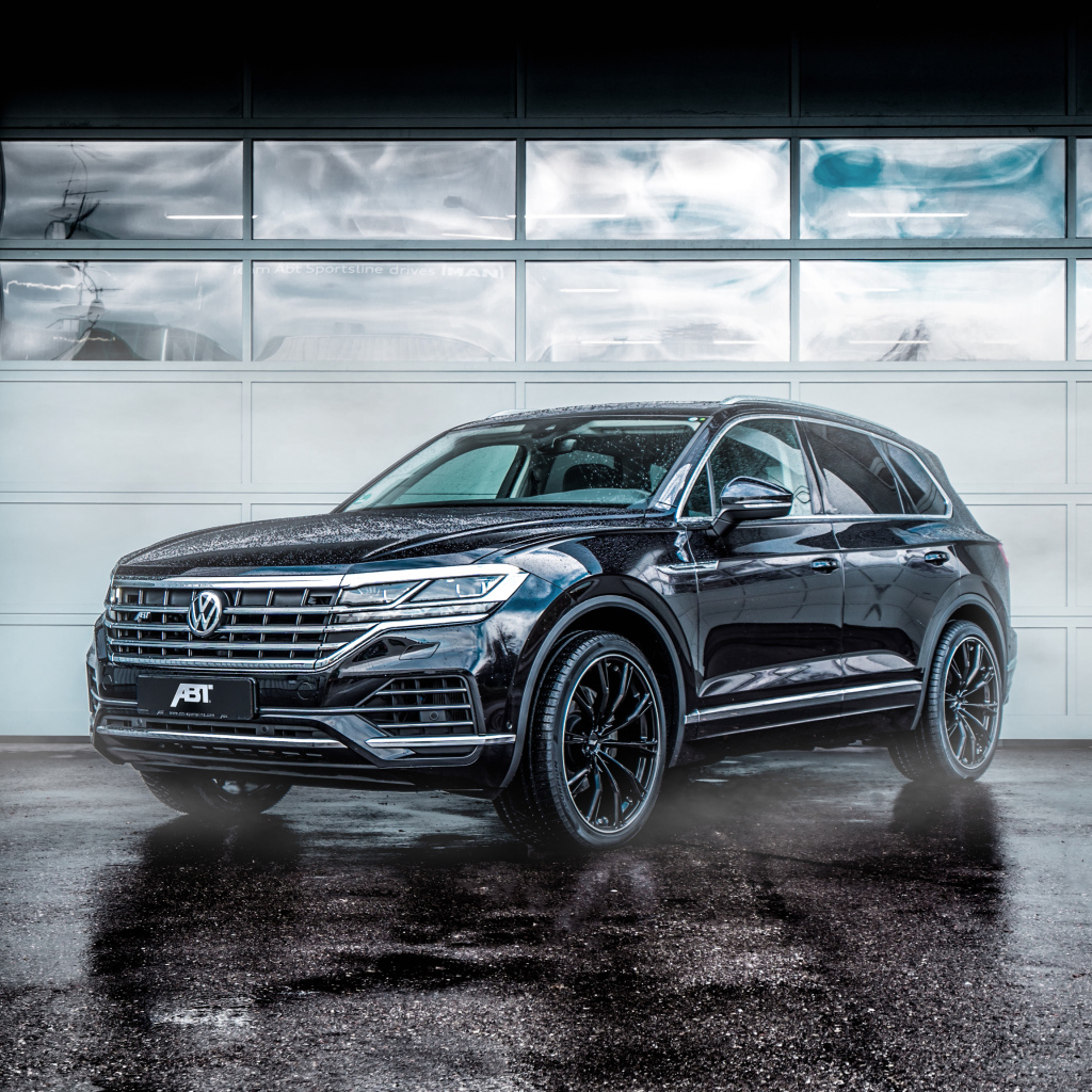 Черный автомобиль Volkswagen Touareg 2018 года у гаража