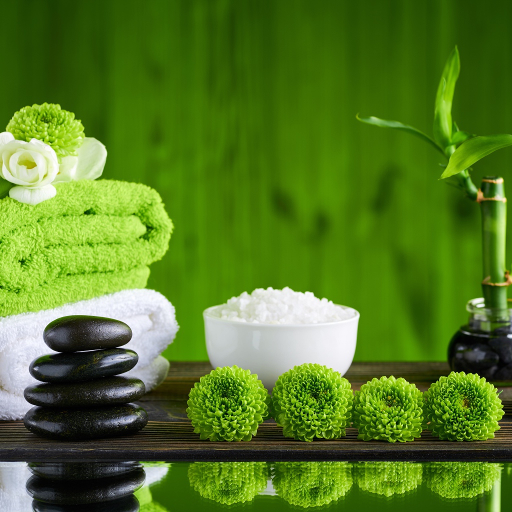 Черные камни, полотенца, соль и цветы у воды для SPA