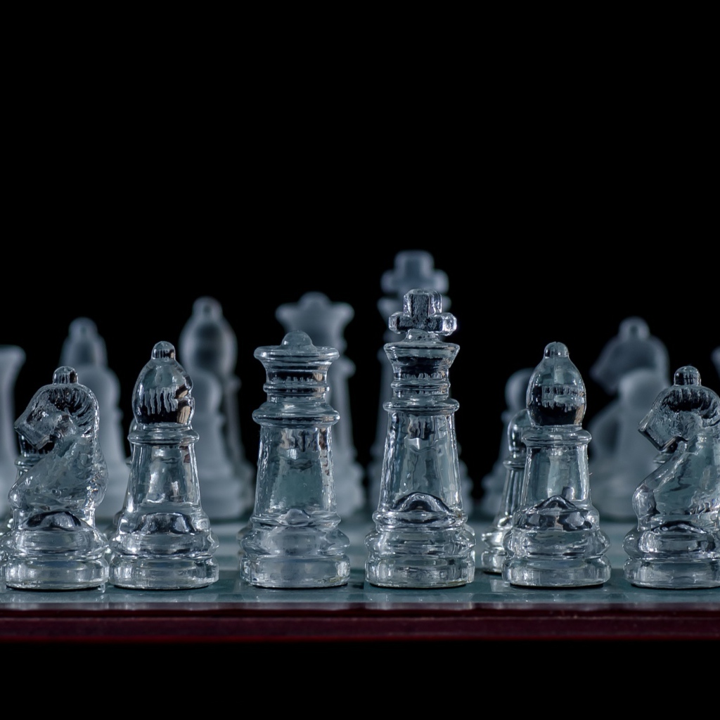Glass chess on a chessboard on a black background