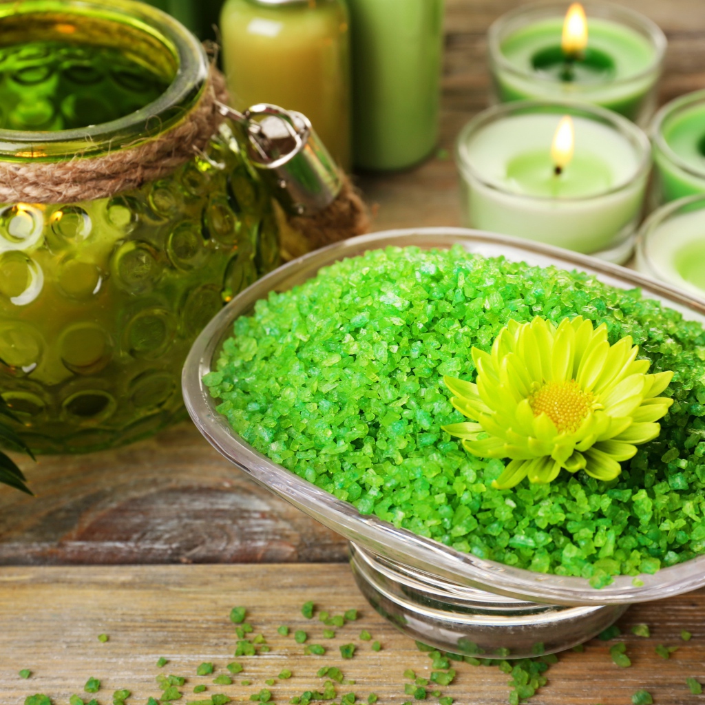 Зеленая ароматная морская соль на столе с зажженными свечами