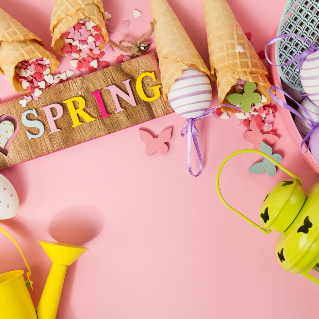 Надпись весна с вафельными рожками и яйцами на розовом фоне