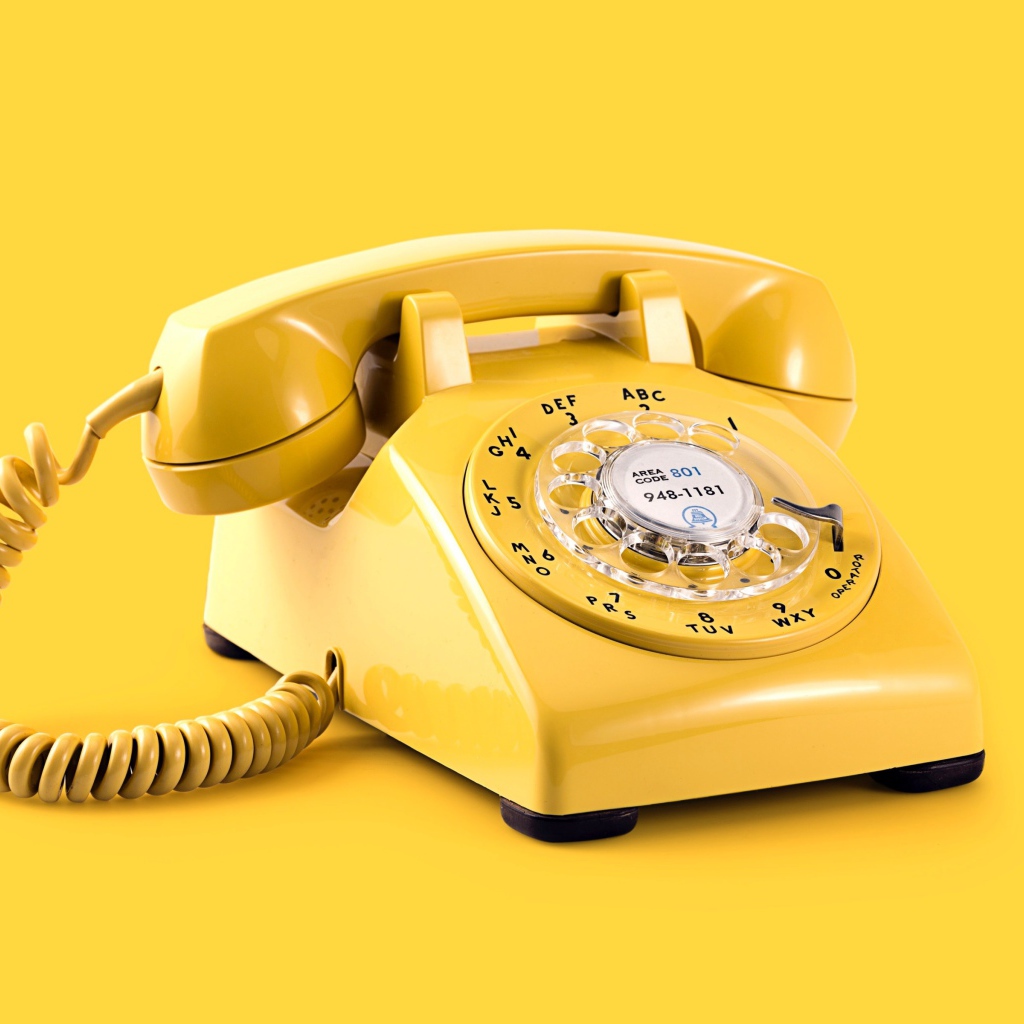 Старый желтый телефон на желтом фоне