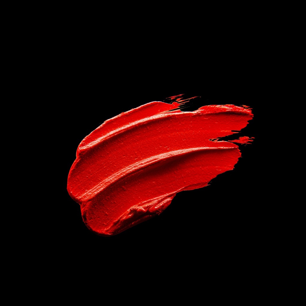 Мазок красной краски на черном фоне