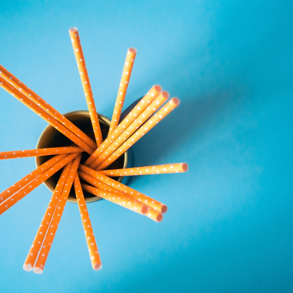 Трубочки в стакане на голубом столе