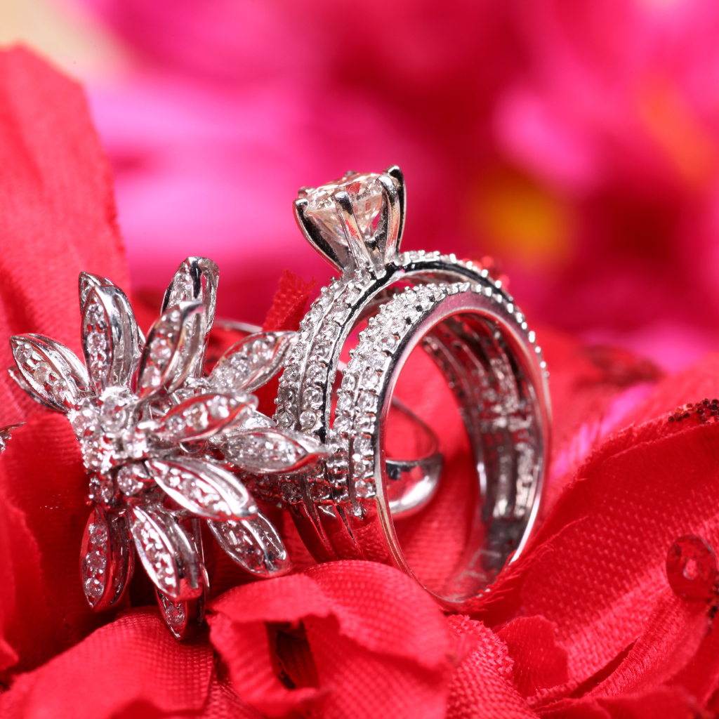 Два кольца с камнями лежат на цветке 