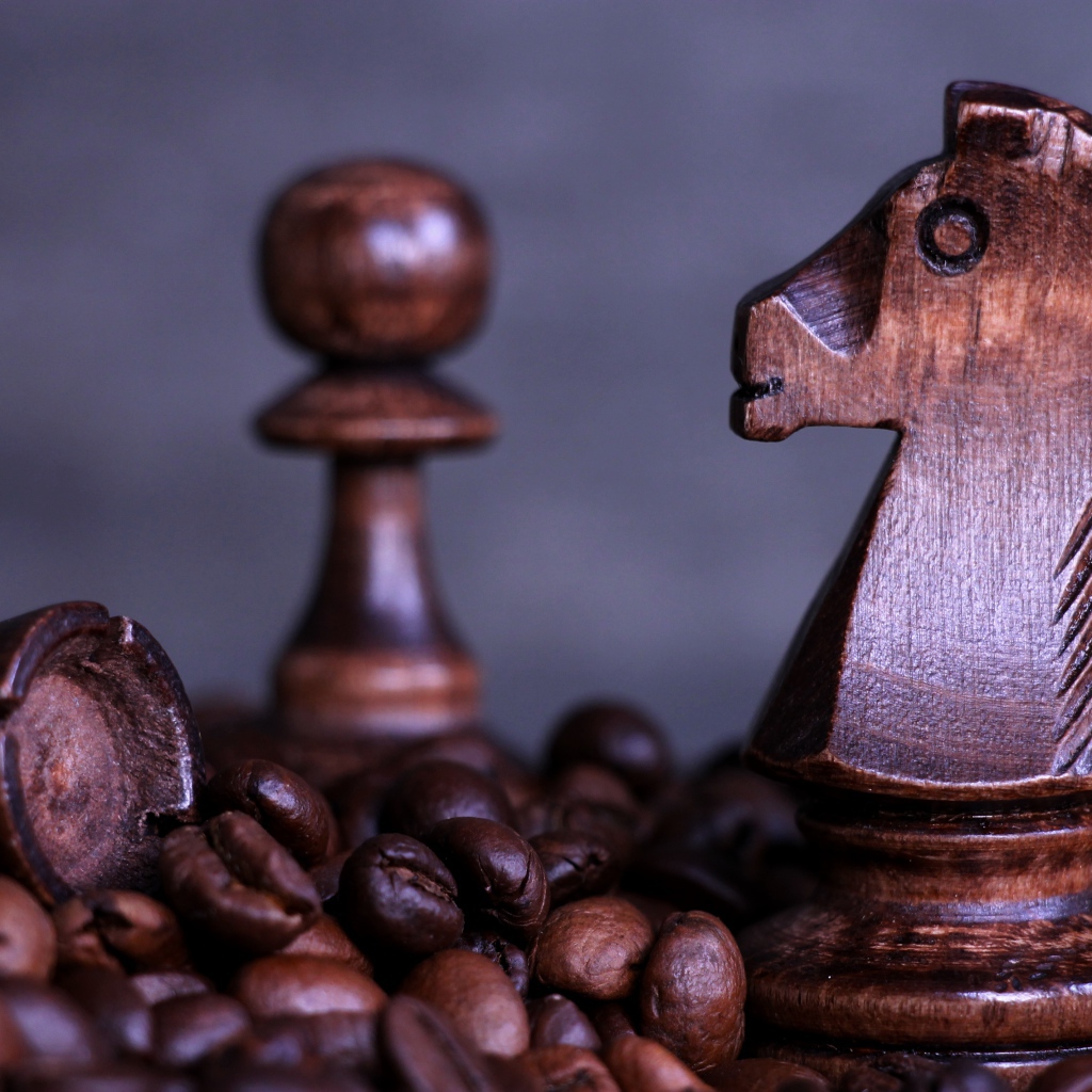 Деревянные шахматные фигуры стоят на кофейных зернах 
