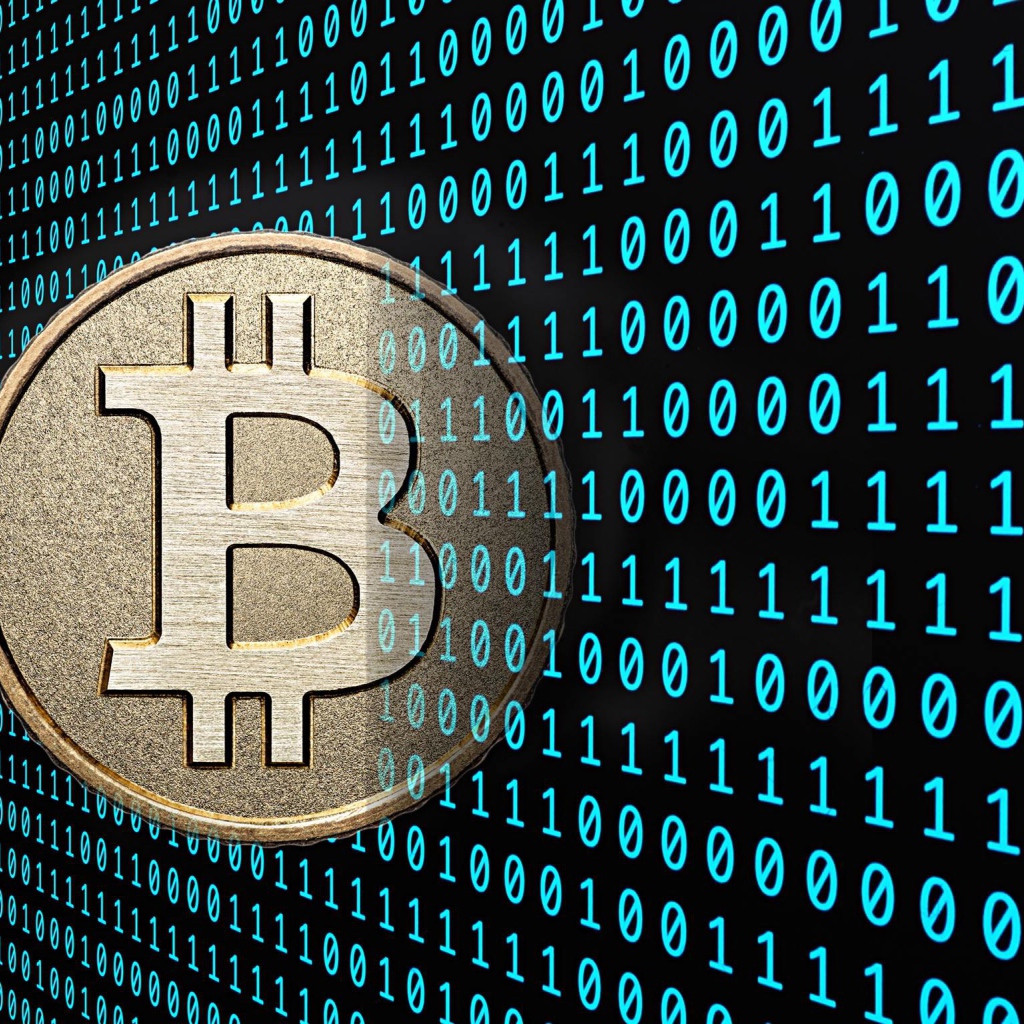 Монета Биткоин на фоне числового кода