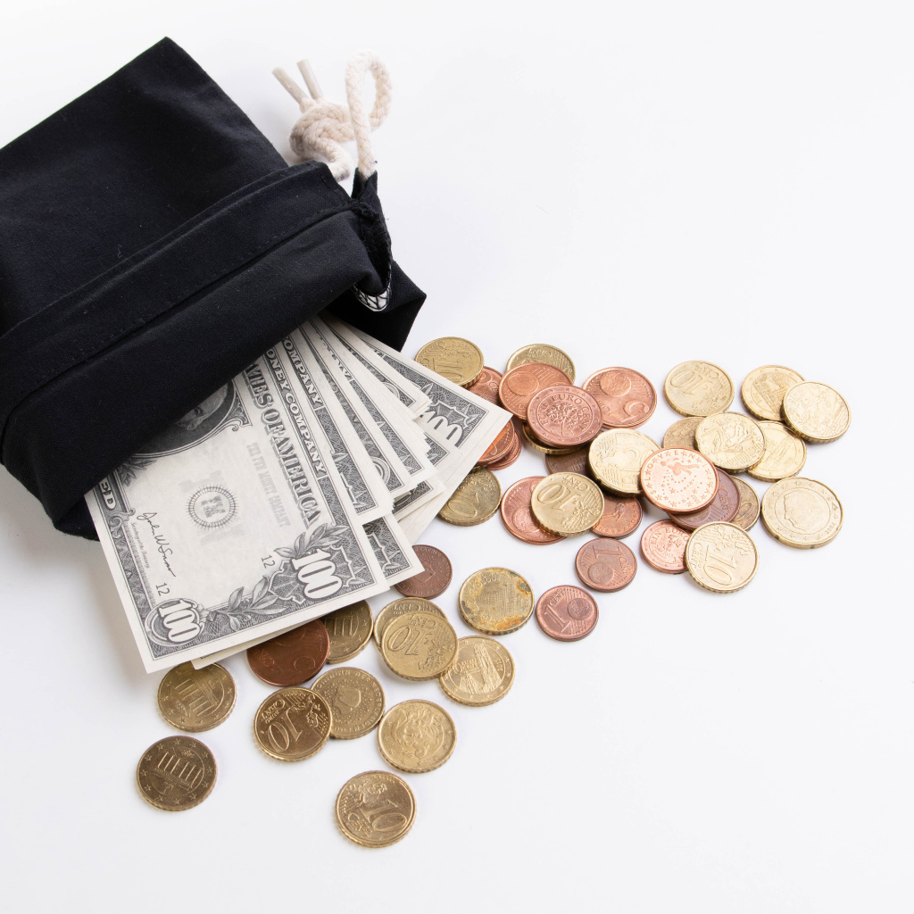 Кошелек с монетами и долларами на белом фоне