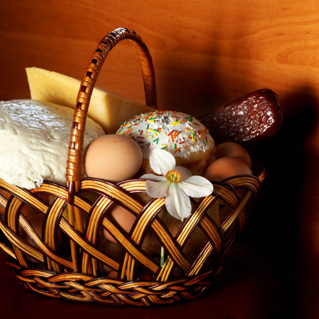Корзина с пасхальными угощениями у стены 