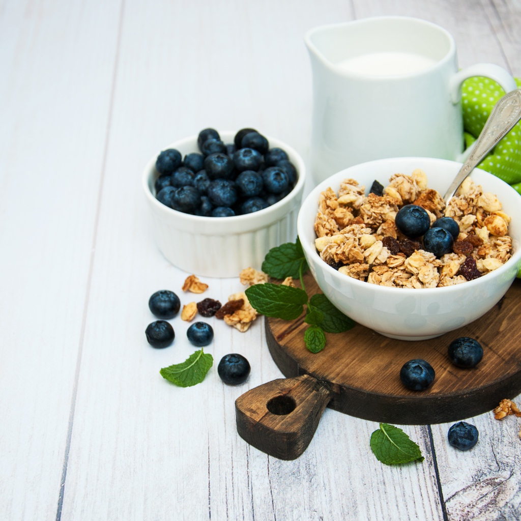 Хлопья с ягодами черники на столе с молоком