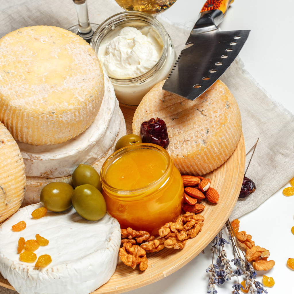 Сыр с плесенью на тарелке оливками, орехами и медом 