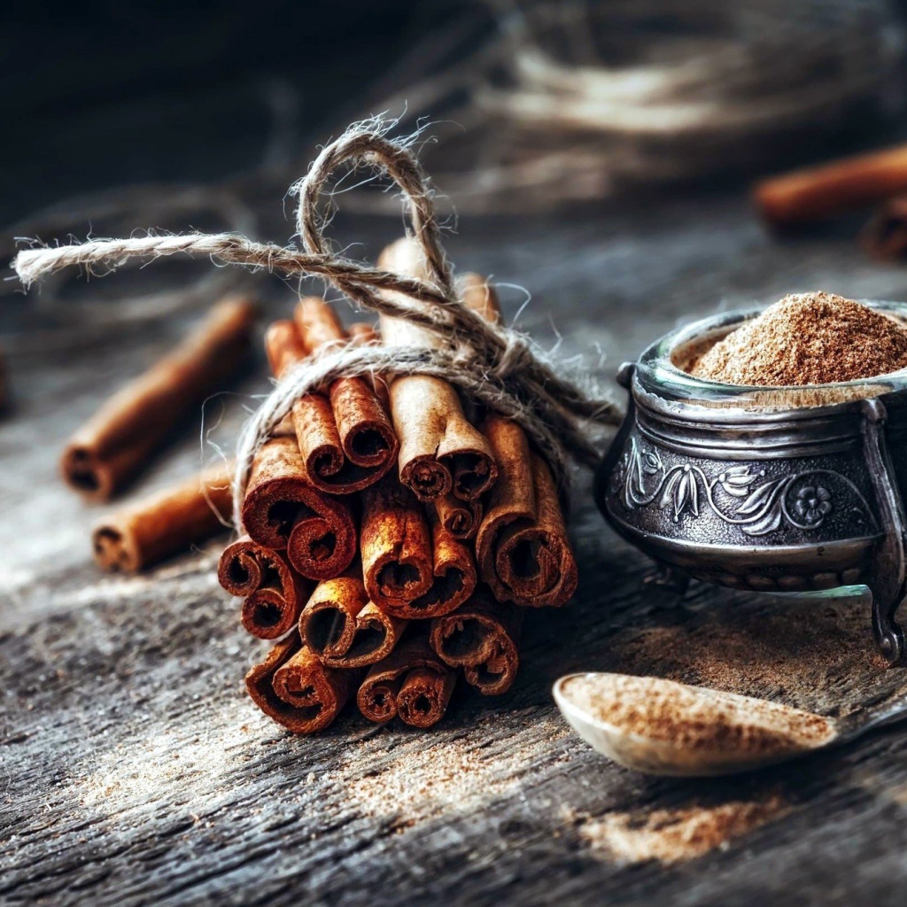 Палочки корицы на столе с молотой корицей