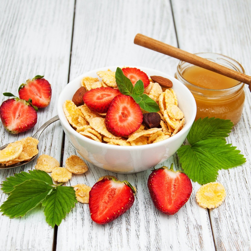 Кукурузные хлопья в миске с клубникой и медом