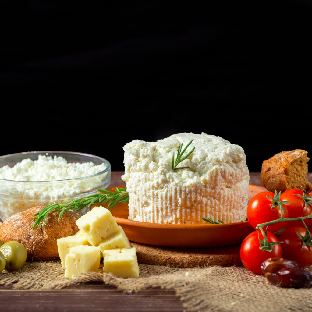 Творог на столе с сыром, хлебом и помидорами