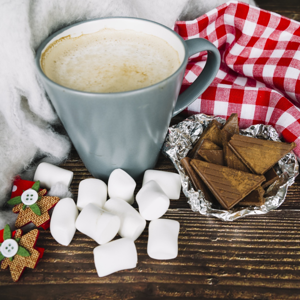 Чашка кофе на столе с маршмеллоу и шоколадом