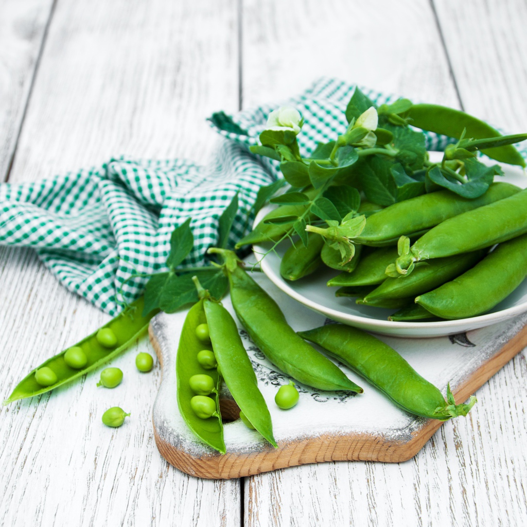 Свежий зеленый горох на столе с полотенцем