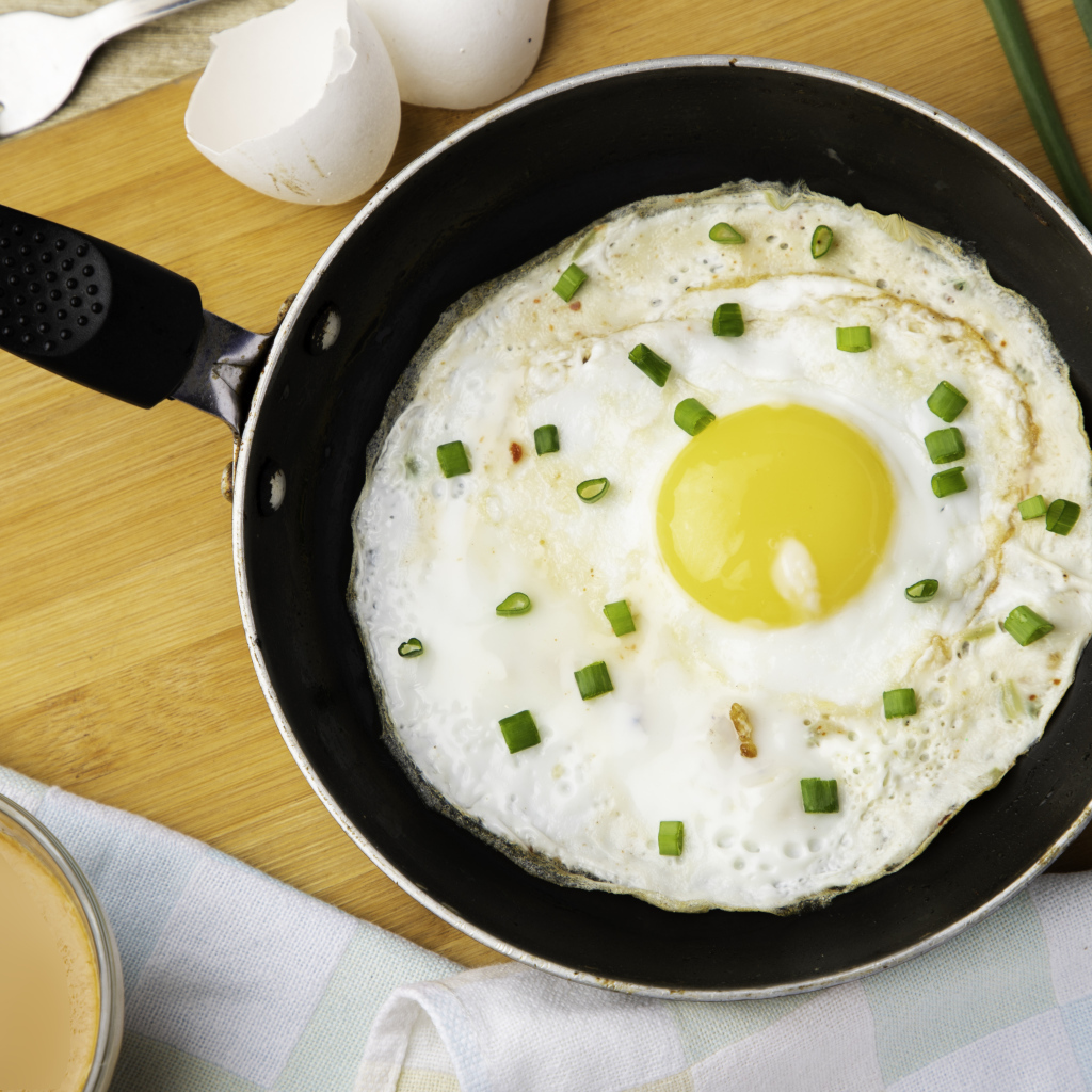 Яичница глазунья на сковороде с зеленым луком