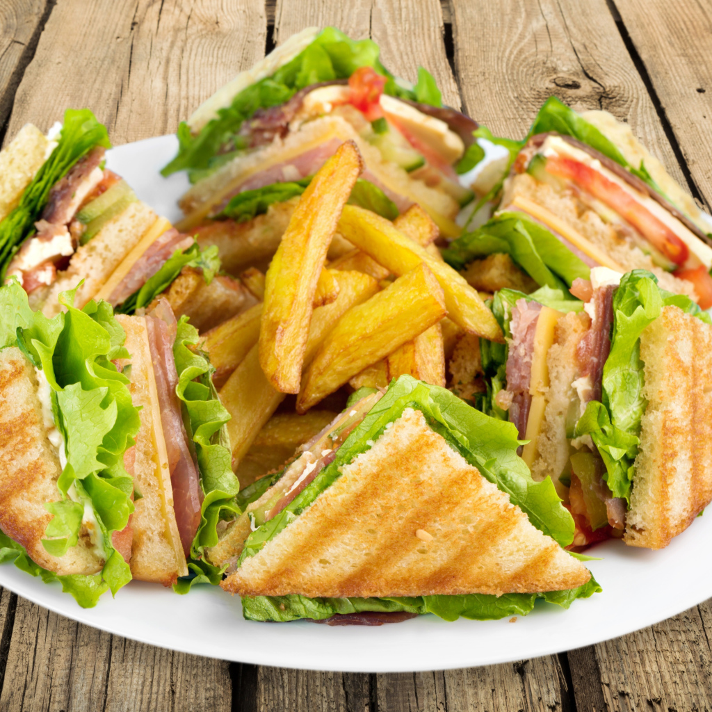 Сэндвичи с ветчиной на тарелке с картофелем фри 