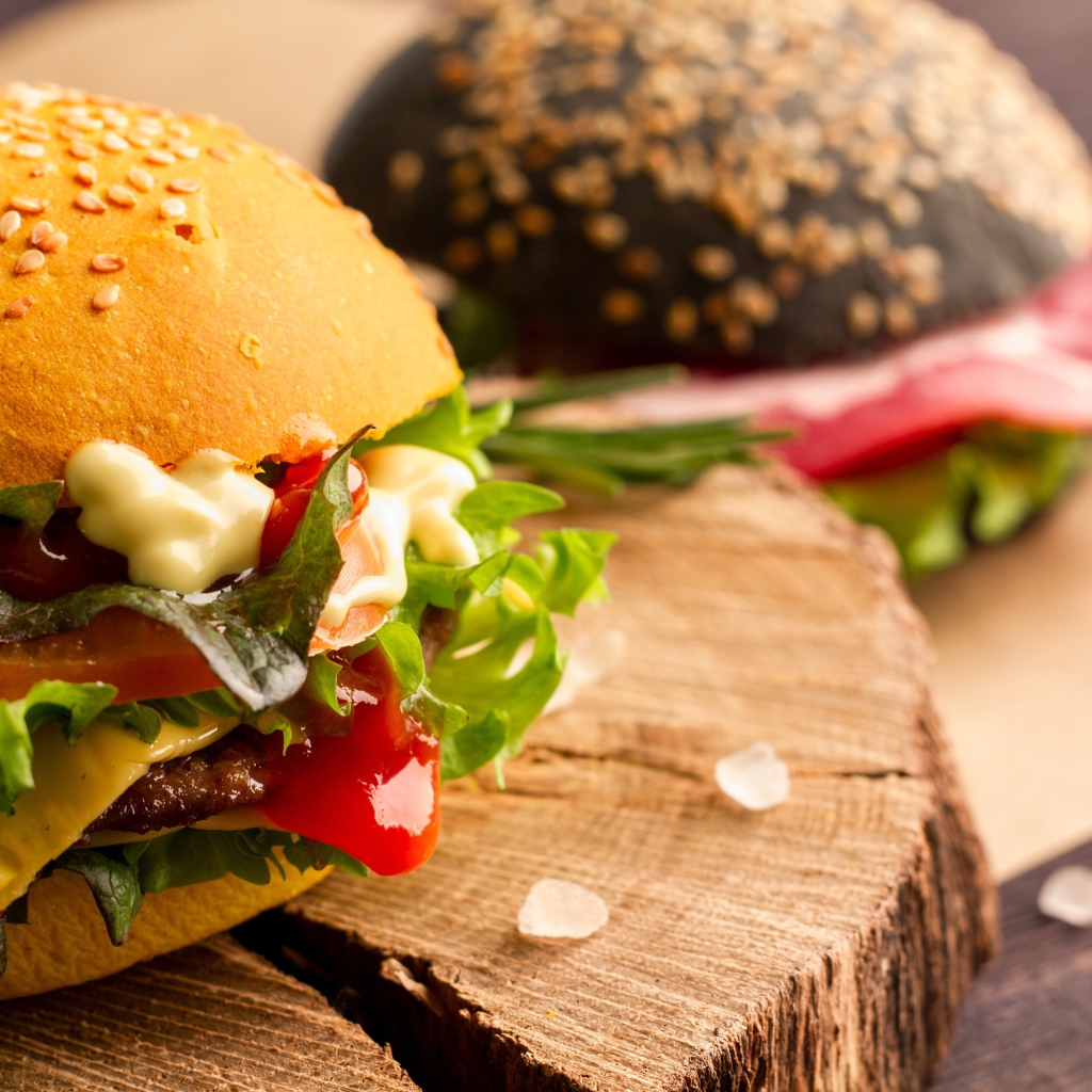 Гамбургер на деревянной доске крупным планом