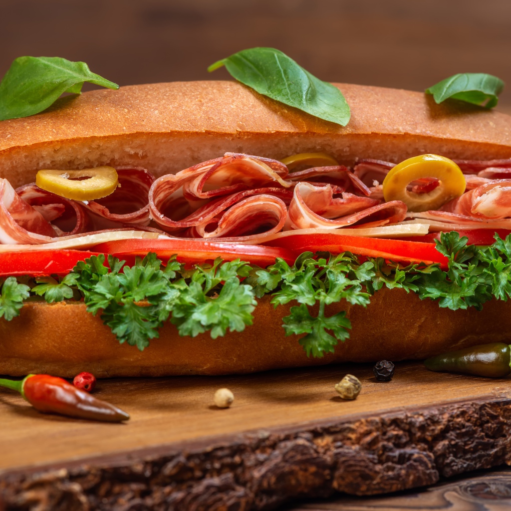 Хот дог с ветчиной, помидорами и листьями петрушки