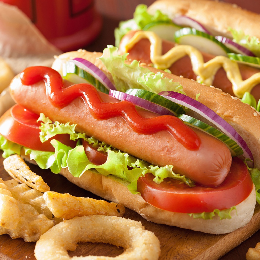 Хотдоги с овощами на разделочной доске с картофелем фри