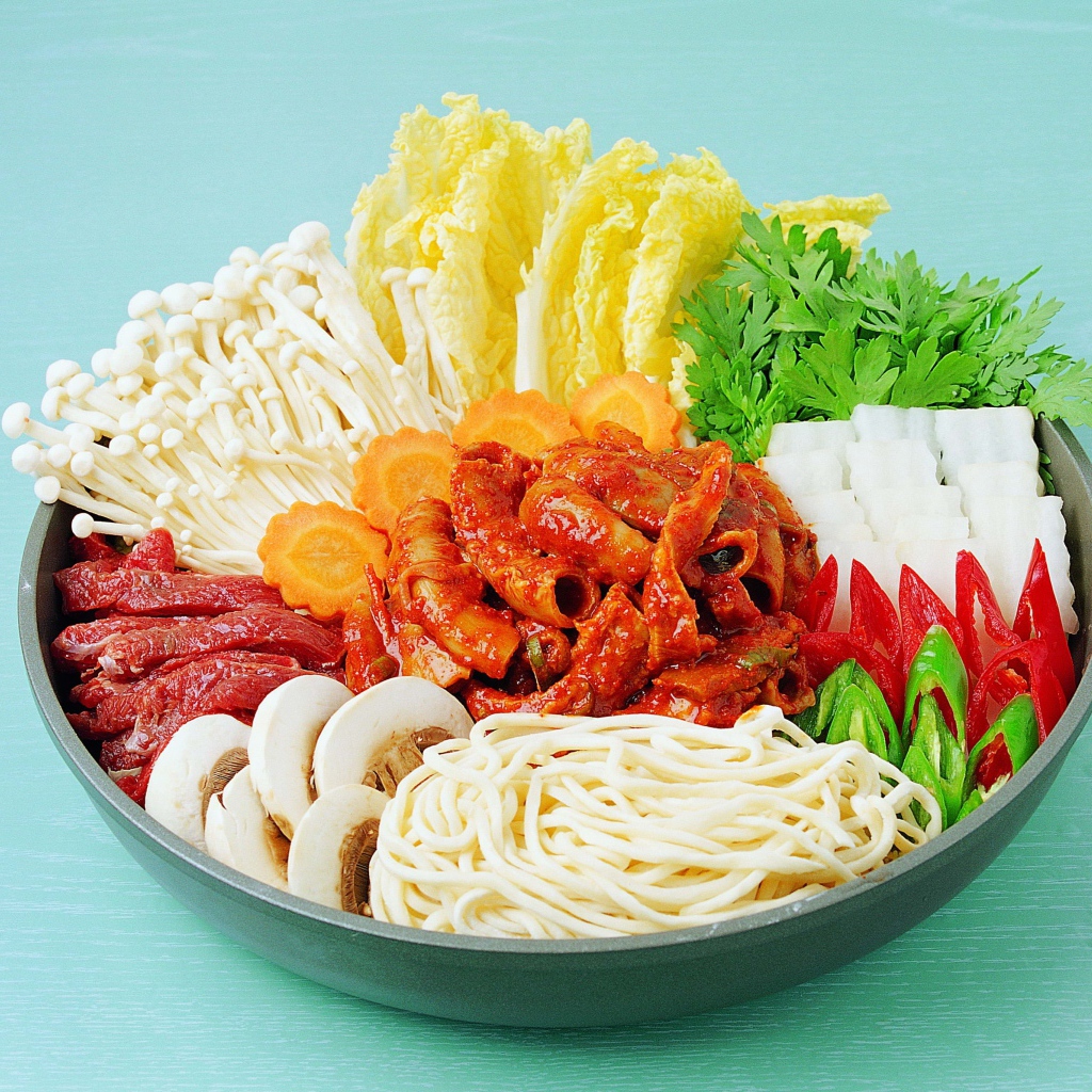 Мясо в тарелке с овощами, грибами и лапшой на голубом фоне