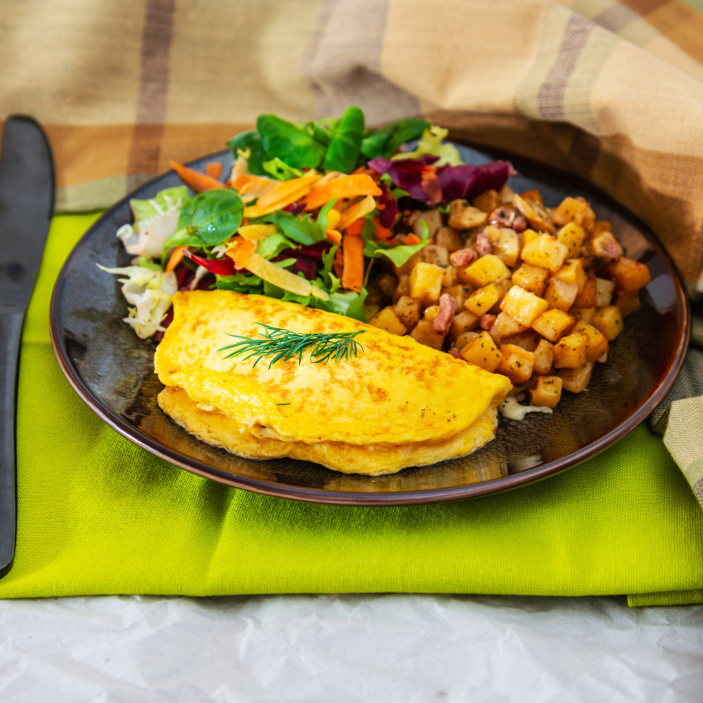 Омлет на тарелке с салатом и овощами