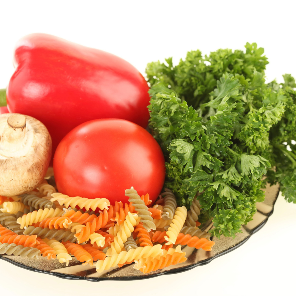 Тарелка с макаронами, красным перцем, помидором, шампиньоном и зеленью петрушки