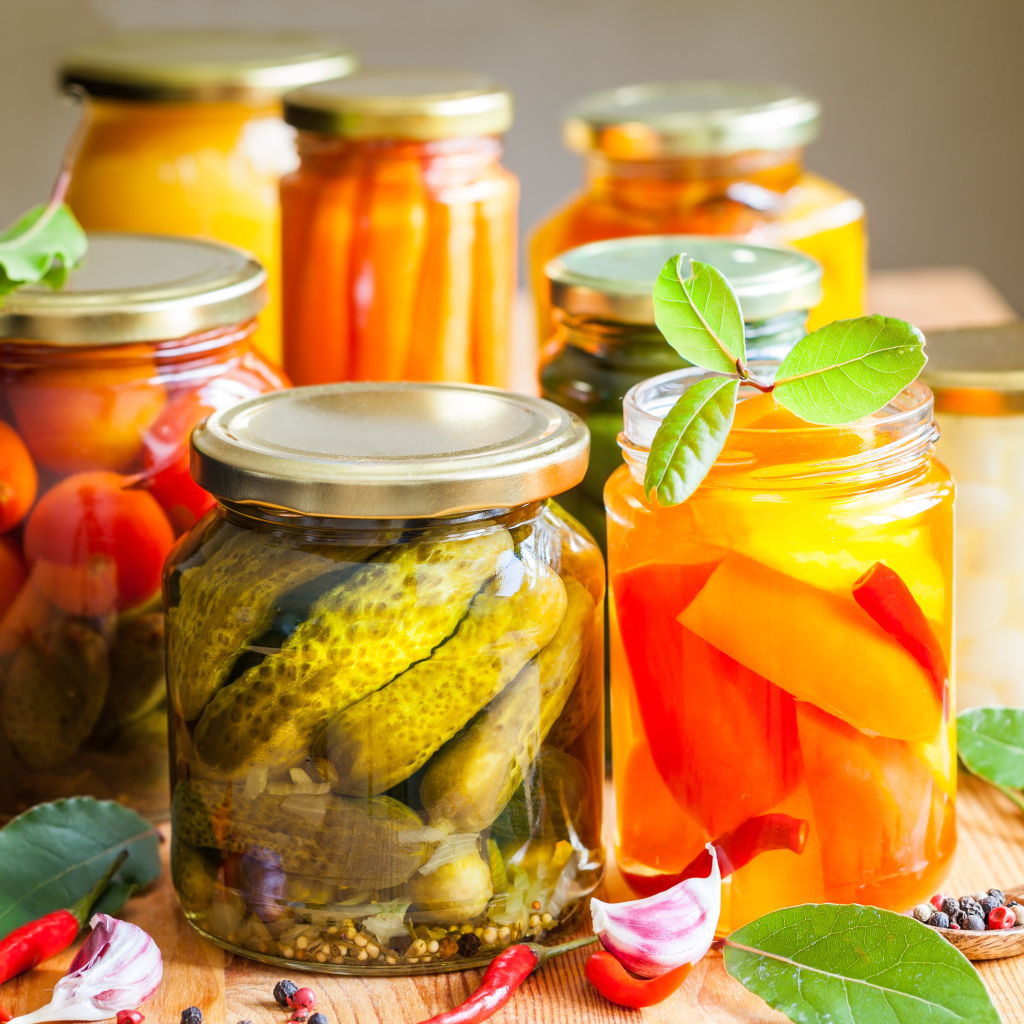 Консервация в стеклянных банках на столе со специями