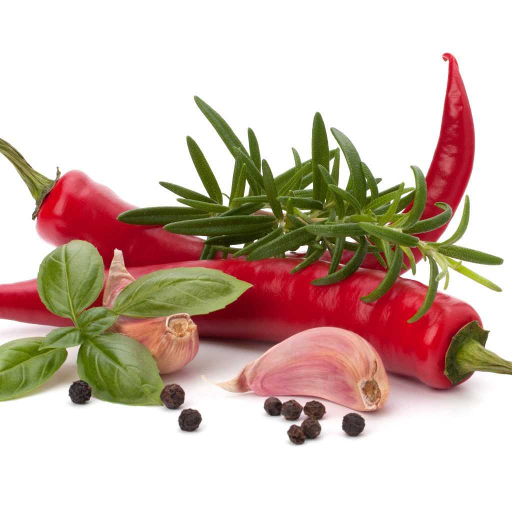 Красный перец с чесноком, базиликом, черным перцем и розмарином на белом фоне