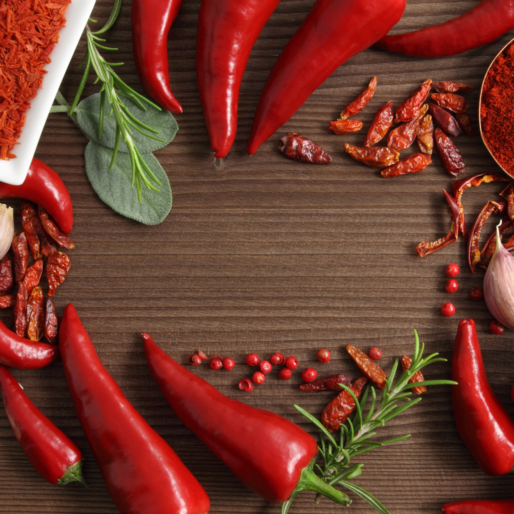 Красный перец с чесноком на деревянном столе